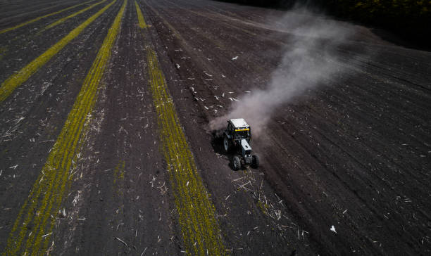 istock Tractor cultivating field at spring, aerial view 806402286