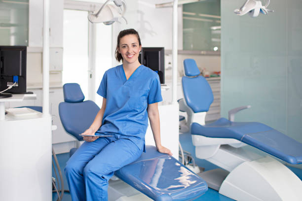 istock Female dentist holding tablet sitting on chair 806402592