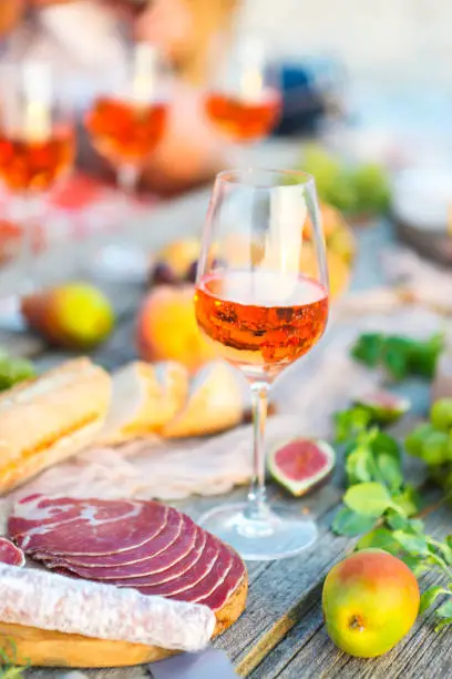 Glass of rose wine and Italian food on wooden table