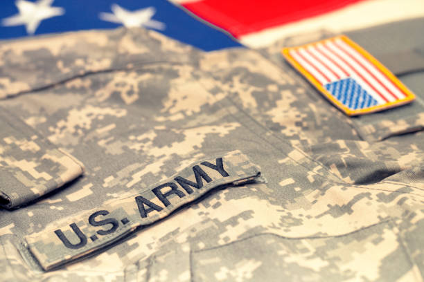istock USA army uniform over US flag - studio shot. Filtered image: cross processed vintage effect. 806473970
