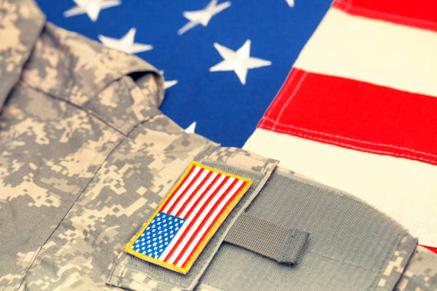 istock USA flag with US army uniform over it - studio shot. Filtered image: cross processed vintage effect. 806476356