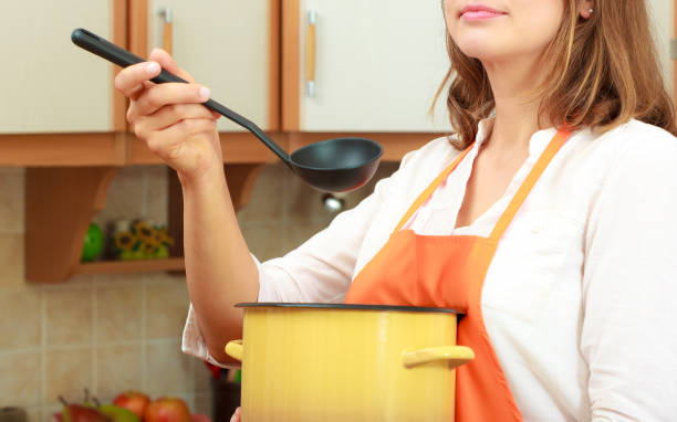 istock Woman with ladle and pot in kitchen 806504586