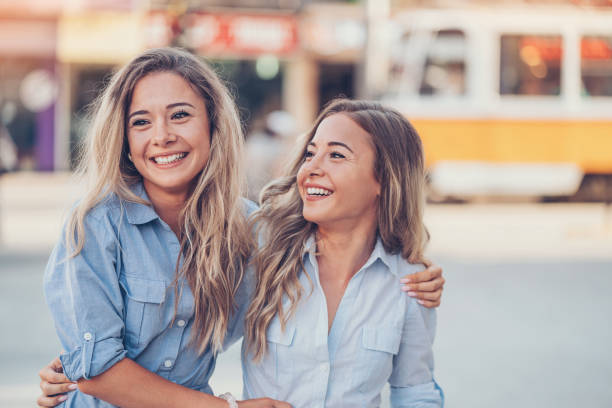 istock Beautiful twin sisters having fun in the city 806511656