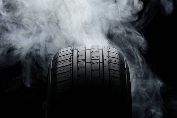 istock Car tire and smoke on black background 806523372