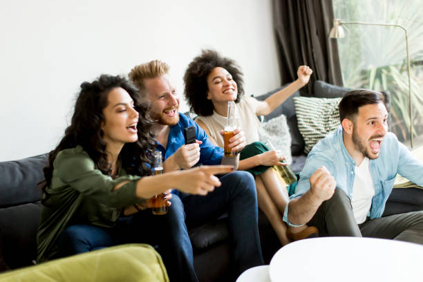 istock Group of friends watching TV, drinking cider and having fun 806564224