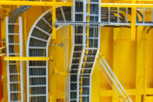 Photo of Cable tray with electrical wiring arrange on ceiling at offshore platform.