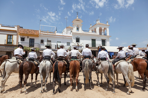 El Rocio, Spain - June 2, 2017: Group of pilgrims on horseback in  traditional spanish dress in El Rocio during the Romeria 2017. Province of Huelva, Almonte, Andalusia, Spain