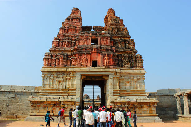 Tourists visiting Vittala temple in Hampi, Karnataka state in India. The Vittala temple at Hampi is one of the largest temples built in the period 1422-46 A.D by Vijayanagar empire. Hampi is a UNESCO heritage site and is famous for ancient ruins of temples.