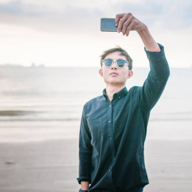 istock Relaxing Businessman using  laptop and smartphone on the beach 806685636