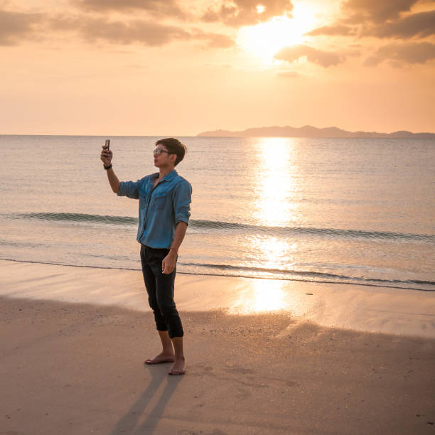 istock Relaxing Businessman using  laptop and smartphone on the beach 806685718