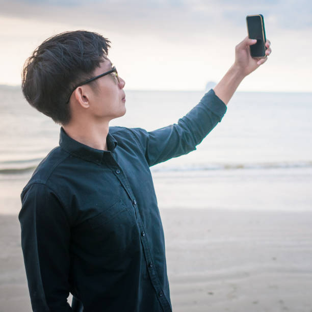 istock Relaxing Businessman using  laptop and smartphone on the beach 806687864