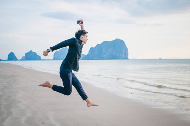 istock Relaxing Businessman using  laptop and smartphone on the beach 806687934