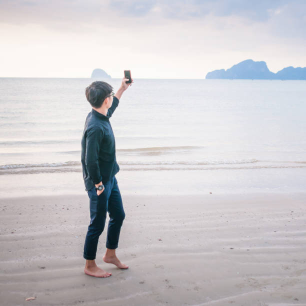 istock Relaxing Businessman using  laptop and smartphone on the beach 806688246