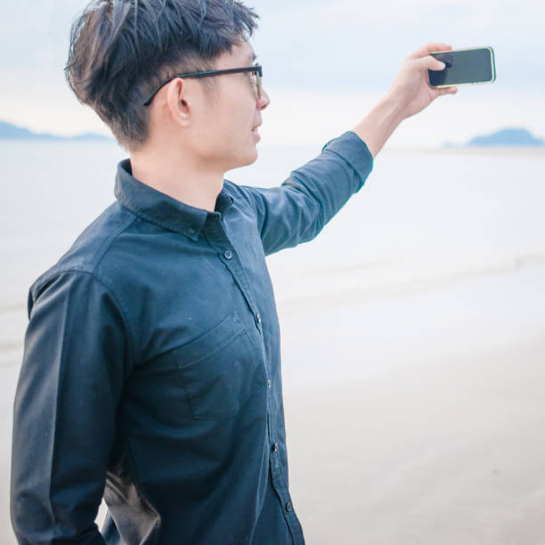 istock Relaxing Businessman using  laptop and smartphone on the beach 806688744
