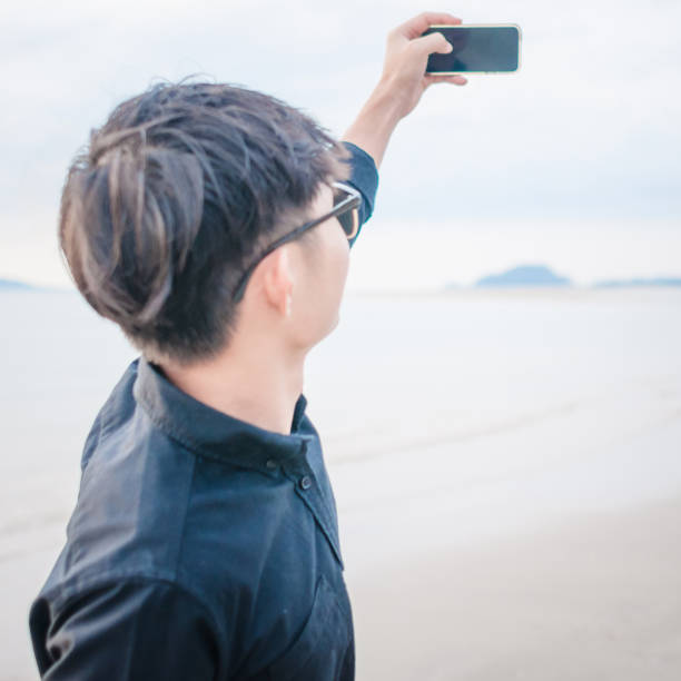 istock Relaxing Businessman using  laptop and smartphone on the beach 806689128