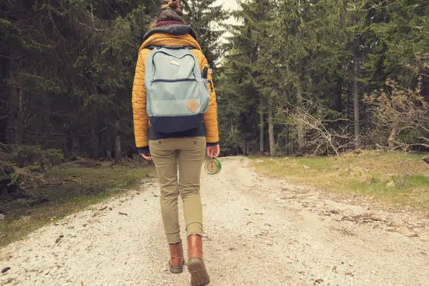 Girl holding a vintage old clock on a empty dirt-road.