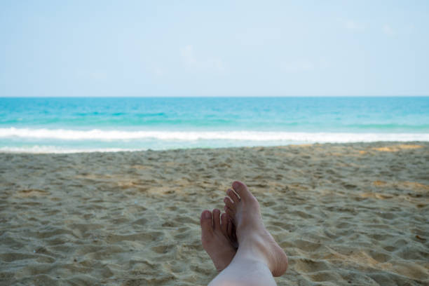 istock Vacation holidays man feet relaxing on beach 806695278