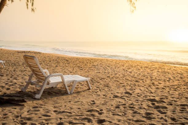 istock white chair on sand beach in morning light 806695390