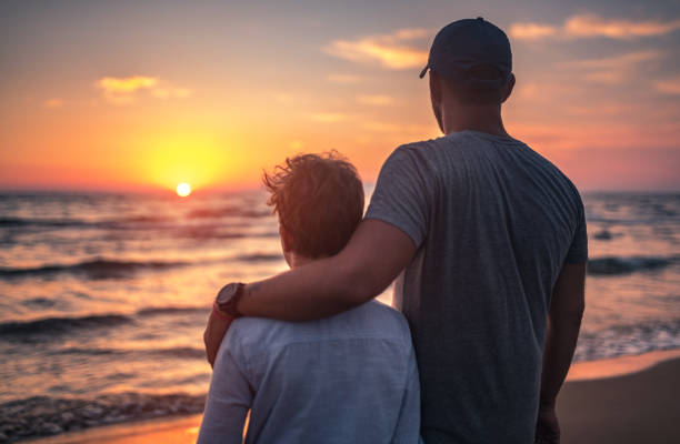 istock Happy father and his son watching sunset at sea 806695586