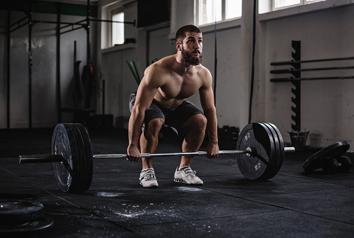 Bodybuilder exercising with barbells in the gym