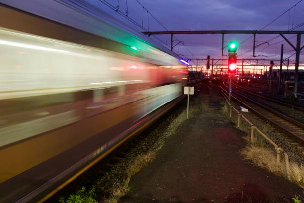 Train moving with red and green signal Blurred train moving at speed at night railway signal stock pictures, royalty-free photos & images