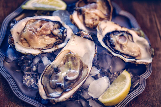 istock Oysters on plate with ice and lemon 806707778