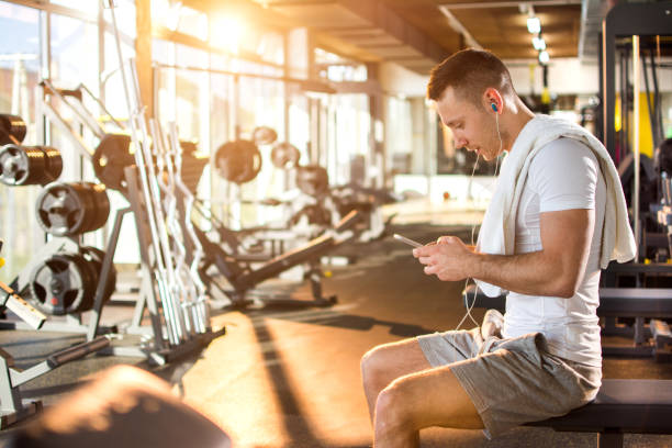 istock Young muscular man using mobile phone at the gym. 806714250