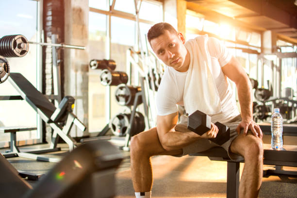 istock Handsome young man lifting weights in gym. 806714338