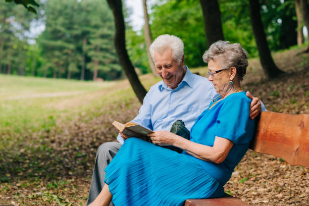 istock Grandparents reading book in the park 806721314