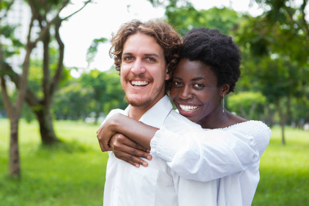 istock Joyful mix-raced couple cuddling in summer park 806730058