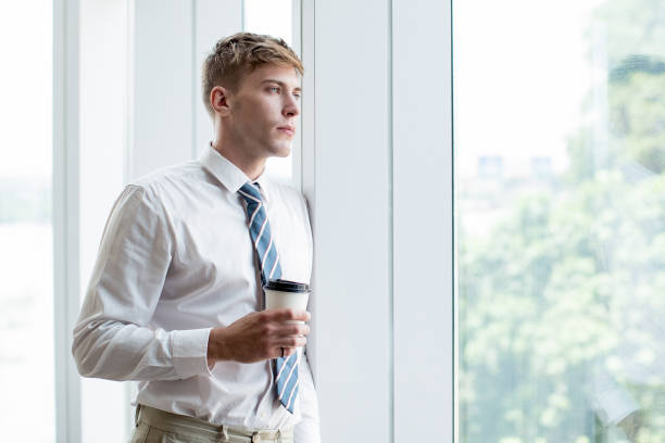 istock Serious Business Man at Window With Drink 806733988