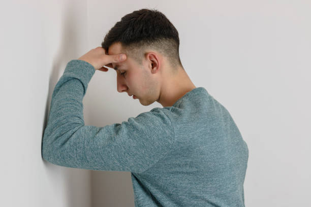 istock Beautiful young depressed boy stands leaning on the wall 806736572