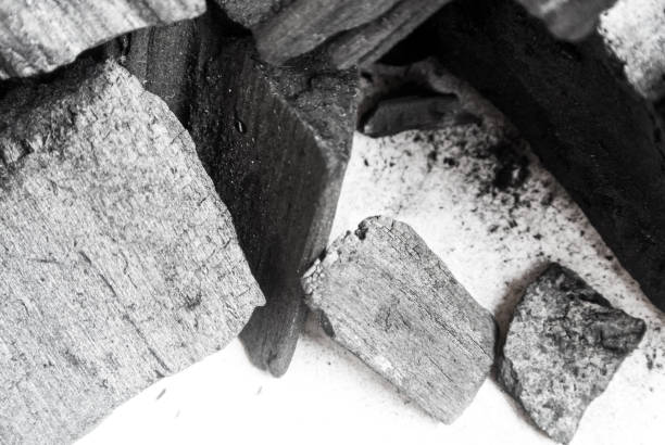 istock Black abstract textured composition on a white background, a selected focus close-up of a pile of cubes and powder of black mineral coal. 806744434