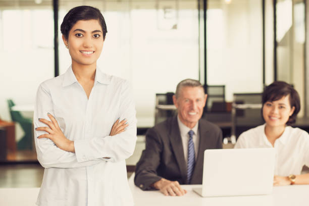istock Smiling Asian woman in office with colleagues 806760316
