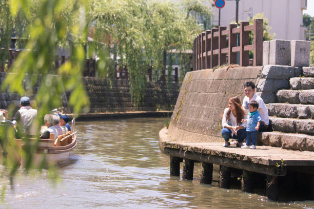 Young family looking at tour boat on river