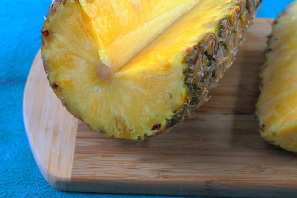 istock Large ripe pineapple on turquoise cement background in tropical theme. 806771254