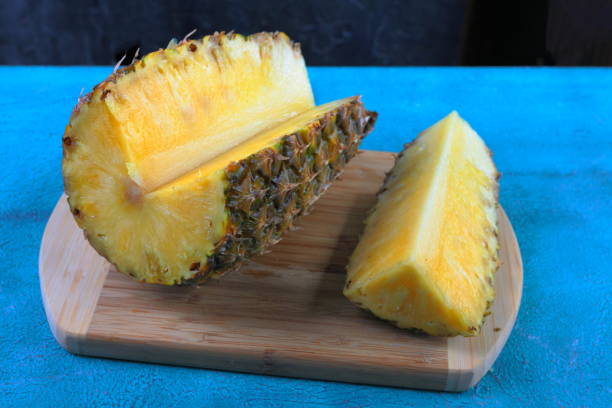 istock Large ripe pineapple on turquoise cement background in tropical theme. 806771320