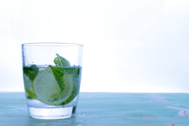 istock Glass with cocktail and ice with lime slice on table. 806775088