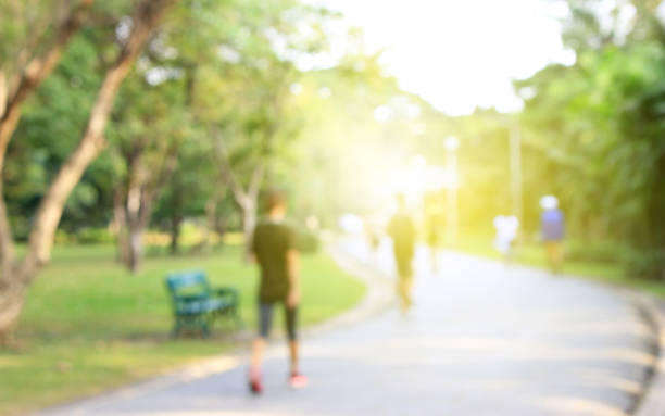 istock Blurred background of people running in park with burst light 806785092