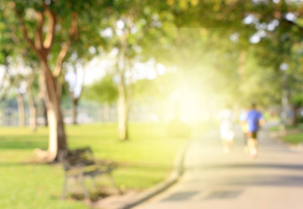 バースト光と公園に走る人々 の背景をぼかした写真 - city street street walking tree ストックフォトと画像