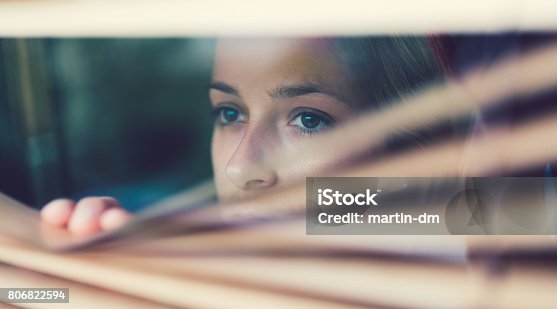 istock Unhappy woman looking through the window 806822594