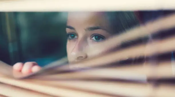 Photo of Unhappy woman looking through the window