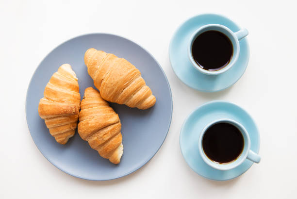istock cup of coffee with croissant on white background 806825380