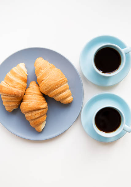 istock cup of coffee with croissant on white background 806826694