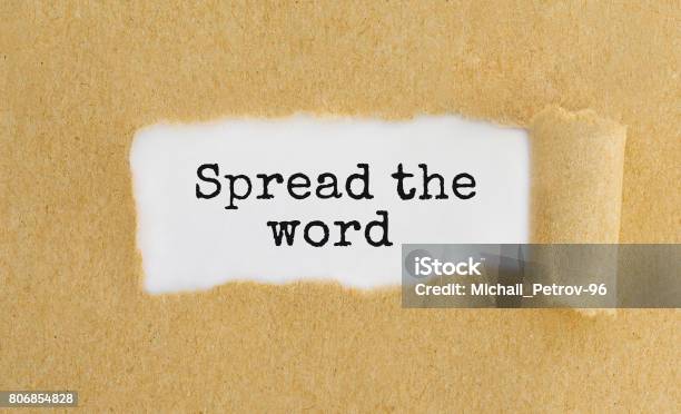 Text Spread The Word Appearing Behind Ripped Brown Paper Stock Photo - Download Image Now
