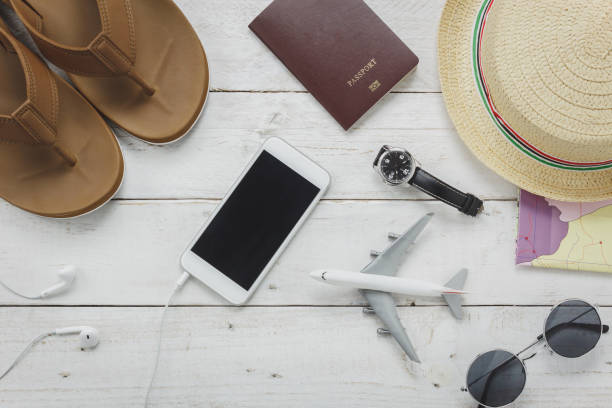 istock Top view essential accessories to travel concept.items for trip slipper,notebook,map,passport airplane,mobile phone,sunglasses on rustic wooden table background. 806855008