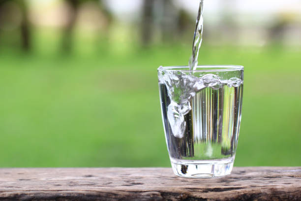 istock Closeup Glass of water on table nature background 806857686