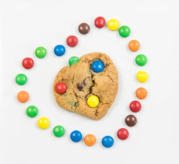 Delicious homemade sweet cookie inside a heart with colorful chocolate sweets