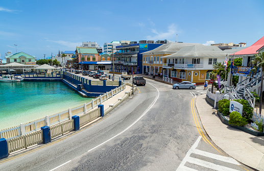 Georgetown, Grand Cayman Island – June 06, 2017: Tourist walking the street and shopping in the popular cruise ship port of Georgetown in Grand Cayman Islands. In the background is the popular bar and restaurant Margaritaville owned by the singer Jimmy Buffett.