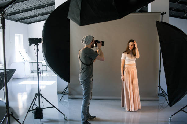 Photographer work in professional studio Photographer work in professional studio . Man taking shot of female model. Photo school, lookbook, fashion backstage concept filming photos stock pictures, royalty-free photos & images